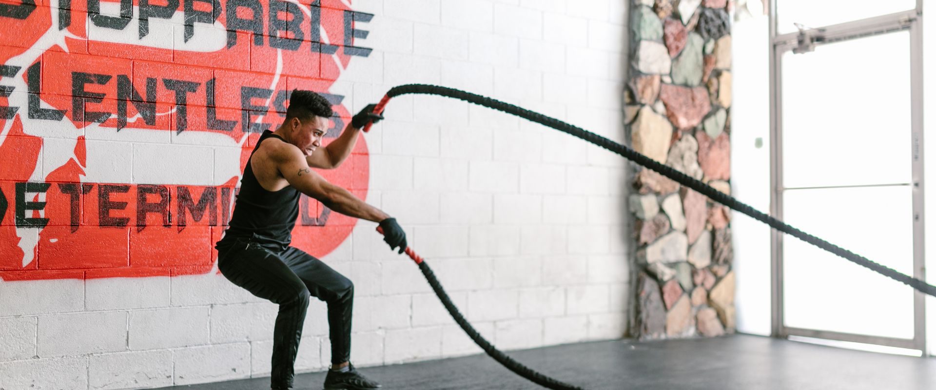 Mand træner med battle ropes