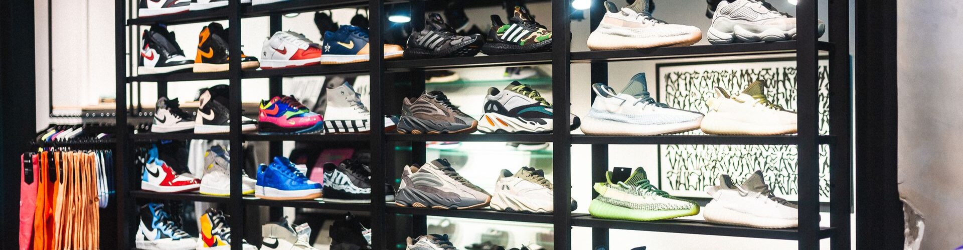Væg med sneakers fra forskellige mærker i en sportsbutik
