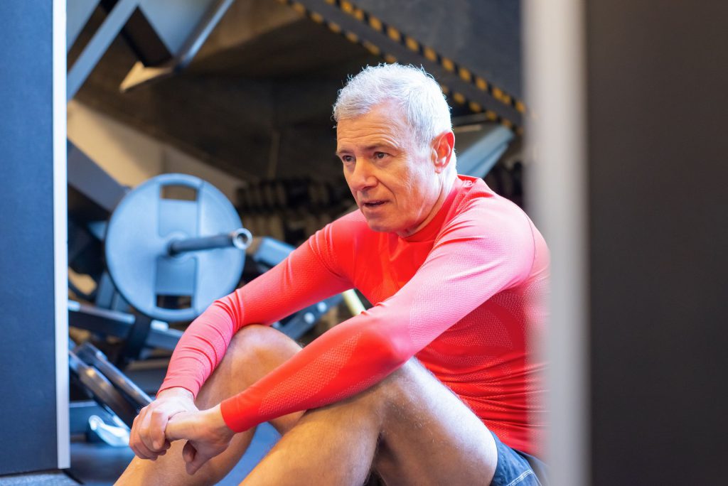 Mand hviler efter træning i fitnesscenter