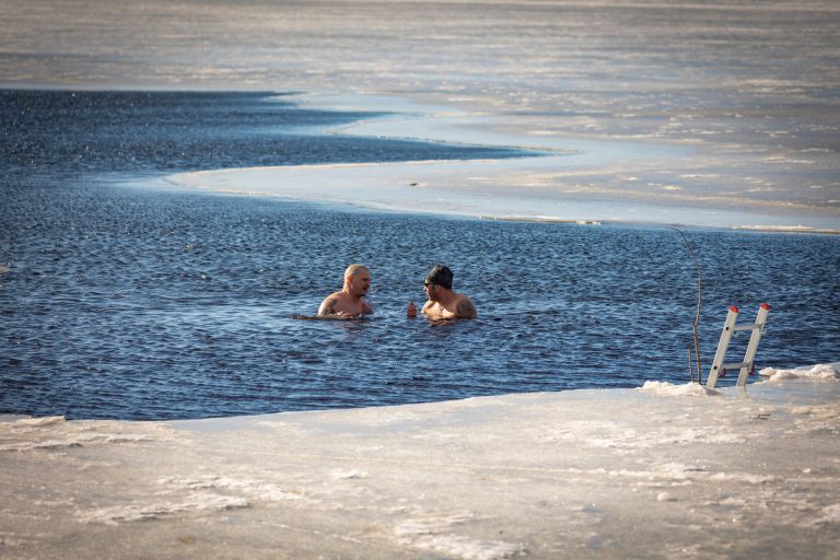 To mænd vinterbader i en frossen sø