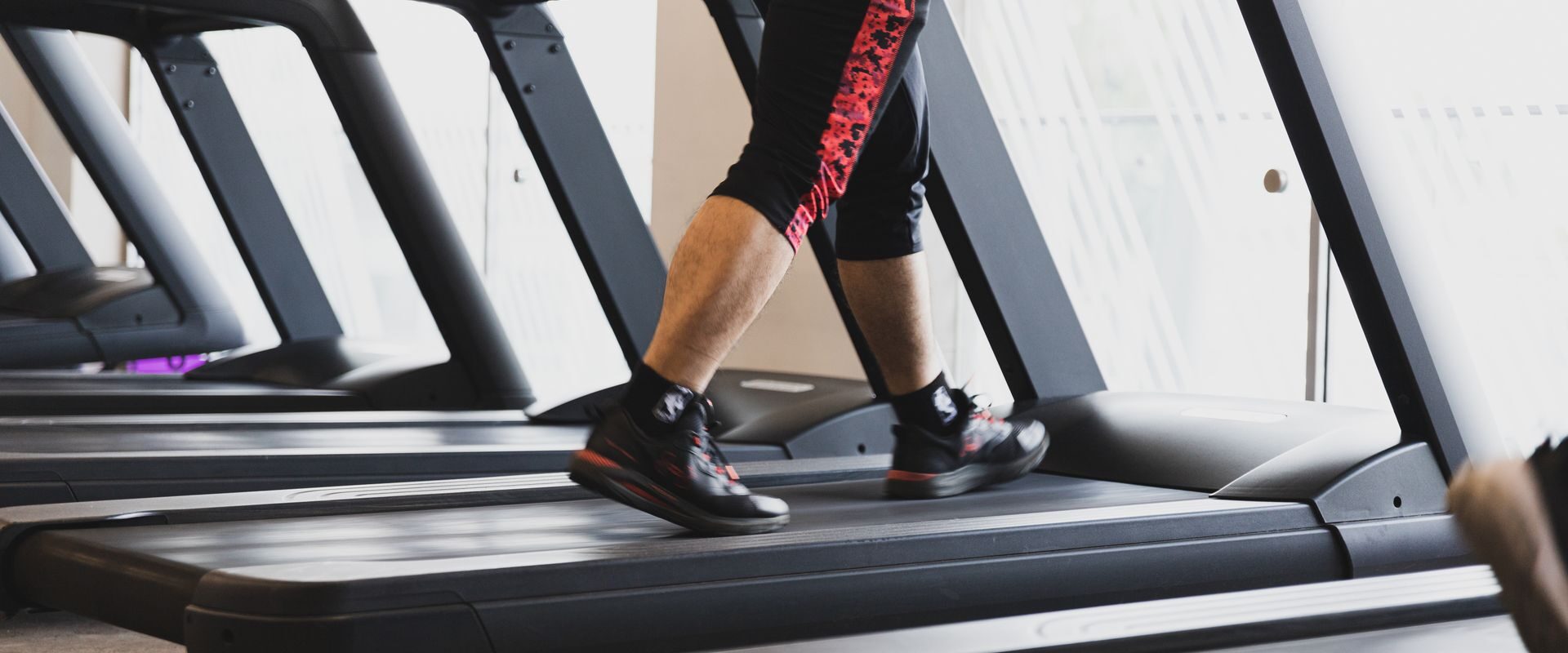 Person der går på et løbebånd i et fitnesscenter