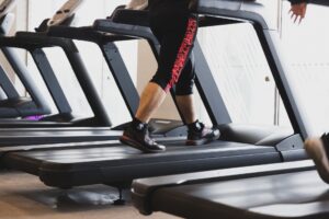 Person der går på et løbebånd i et fitnesscenter