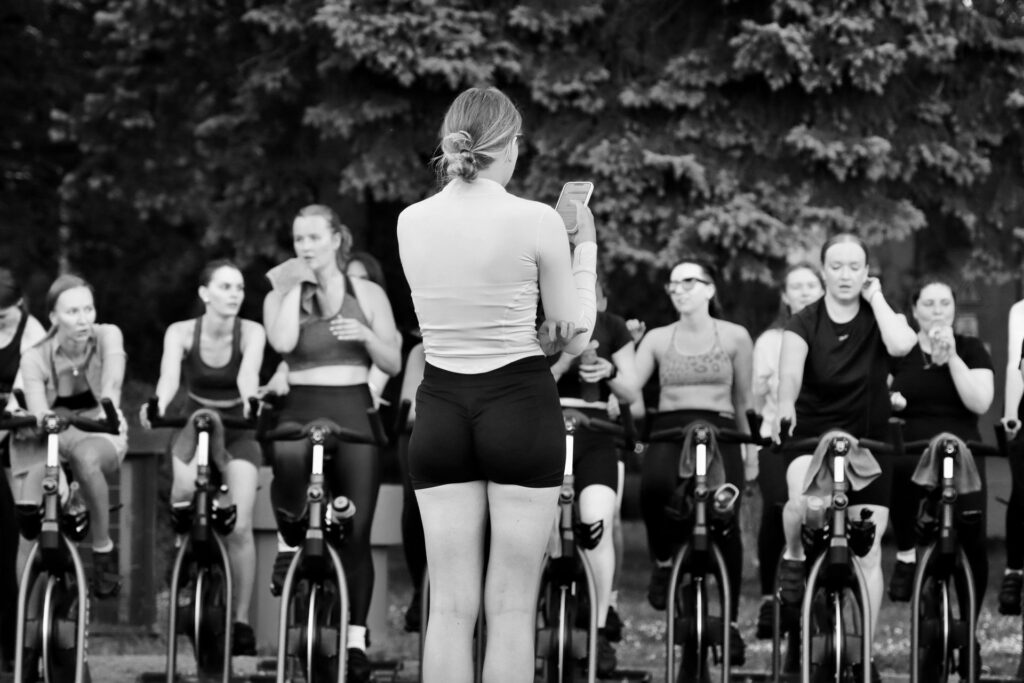 Instruktør og deltagere på spinningcykler i et fitnesscenter
