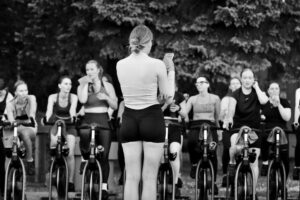 Instruktør og deltagere på spinningcykler i et fitnesscenter