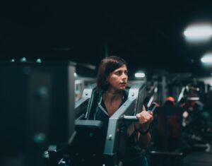 Fokuseret kvinde løfter vægte i fitnesscenter