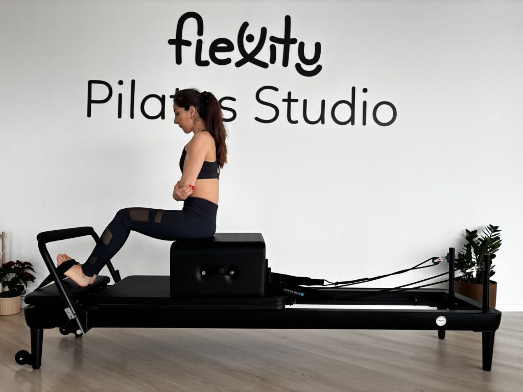 Kvinde der træner på en pilates reformer