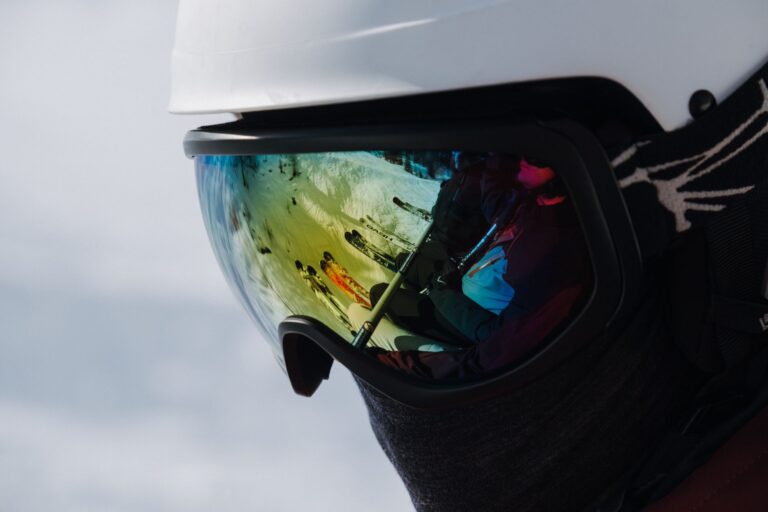 Nærbillede af skibriller, hvor skiløbere spejler sig i linsen