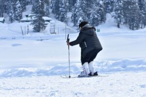 Person der står på ski ned ad en pist