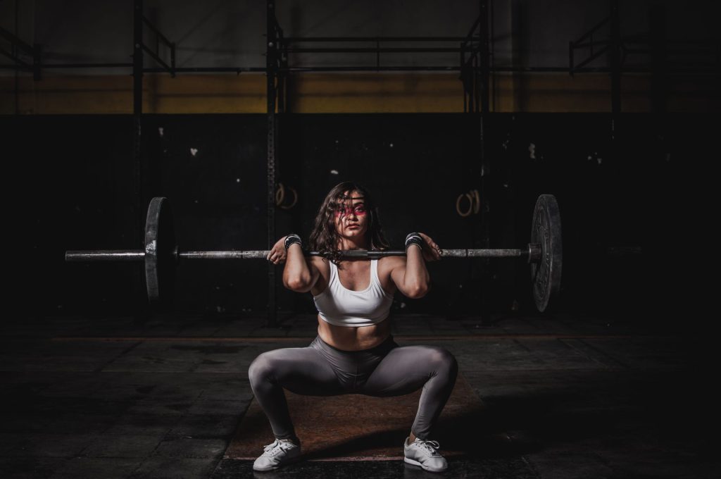 Kvindelig vægtløfter tager squat med vægtstang